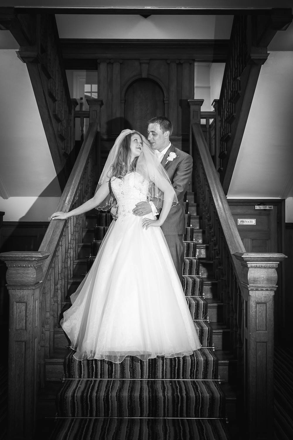 Bride and groom on elegant staircase by Southampton wedding photographer John Watson