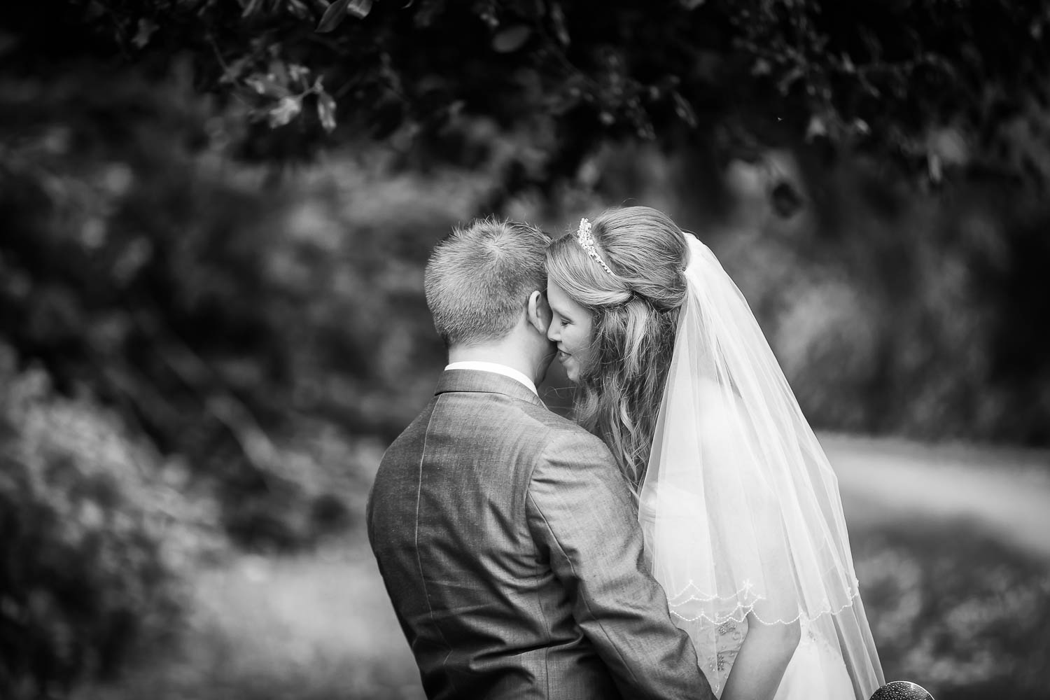 Bride and groom embrace in a romantic garden setting by Southampton wedding photographer John Watson
