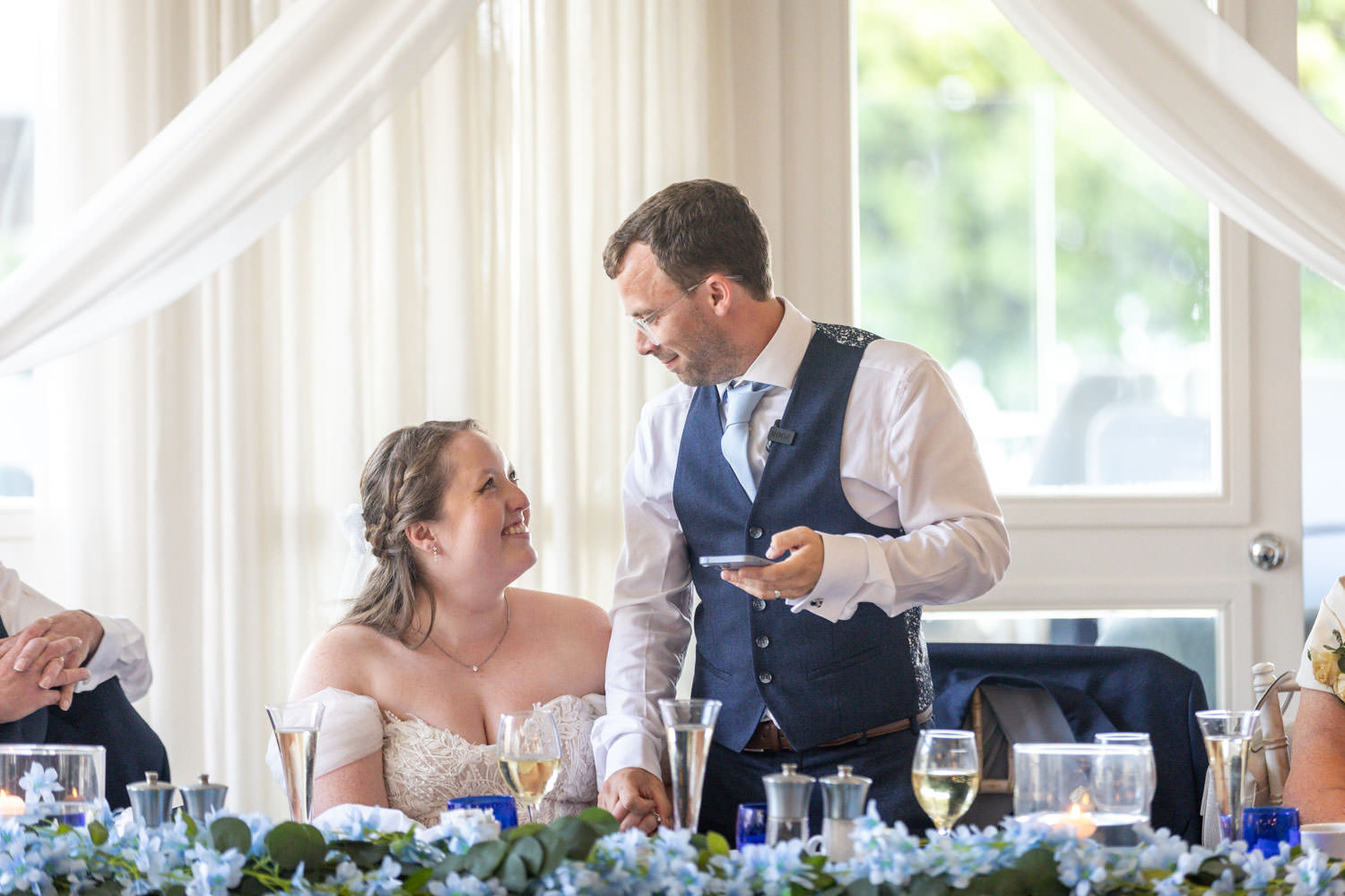 Bride and groom share a joyful moment at wedding reception by Southampton wedding photographer John Watson
