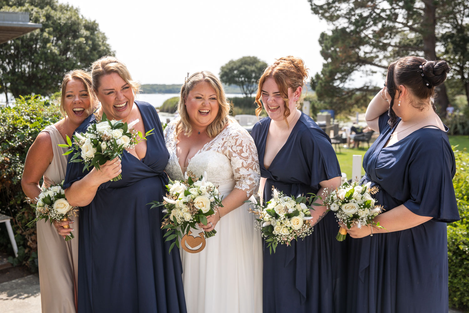 Bride with bridesmaids in navy blue dresses by Southampton wedding photographer John Watson