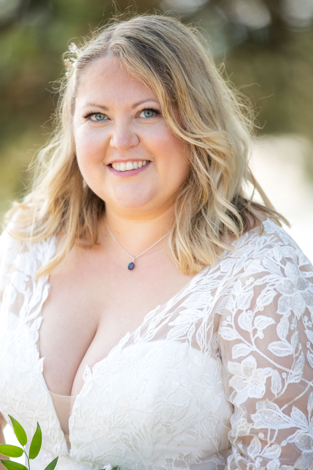 Smiling bride in lace dress on wedding day by Southampton wedding photographer John Watson