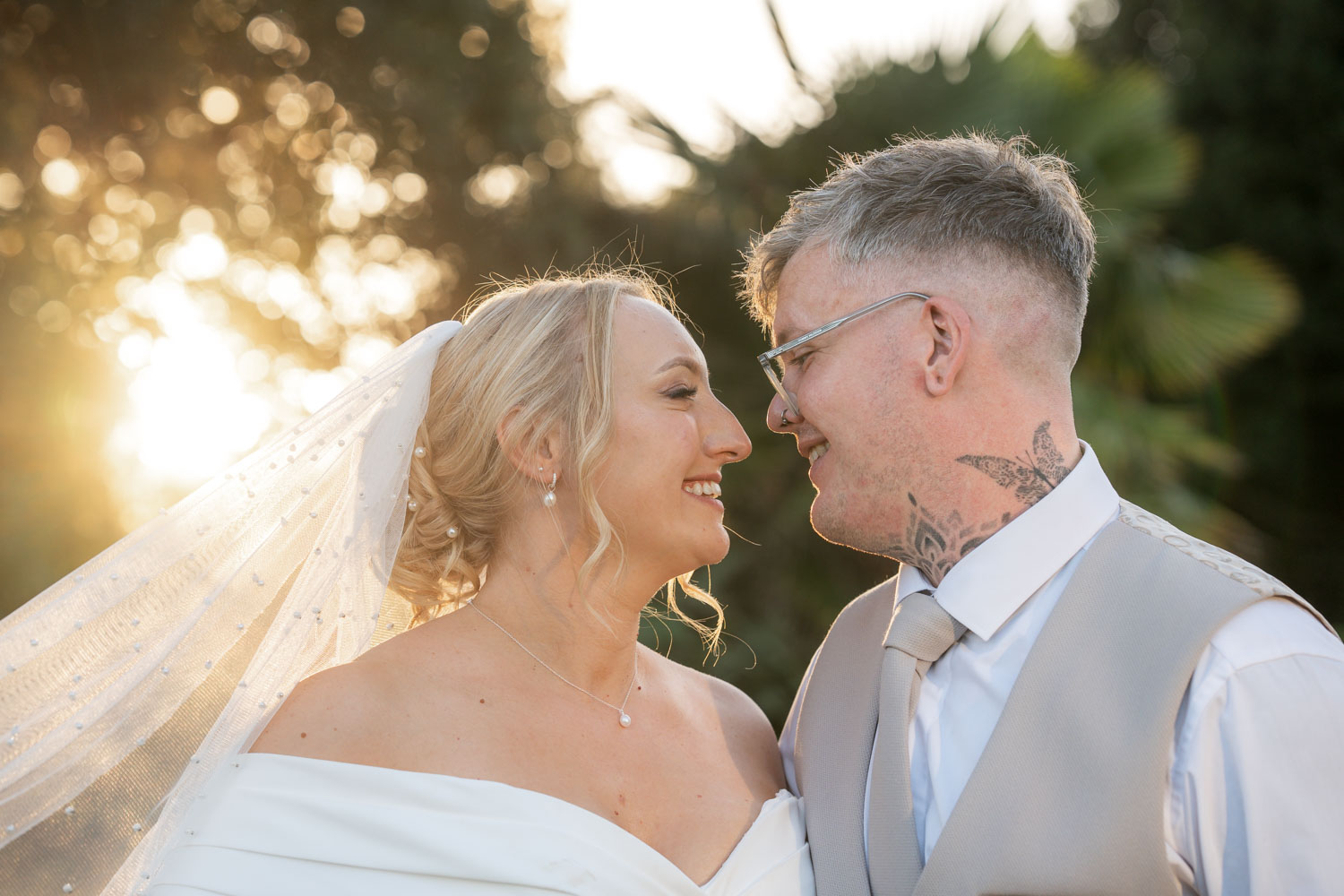 Bride and groom smiling at sunset by Southampton wedding photographer John Watson