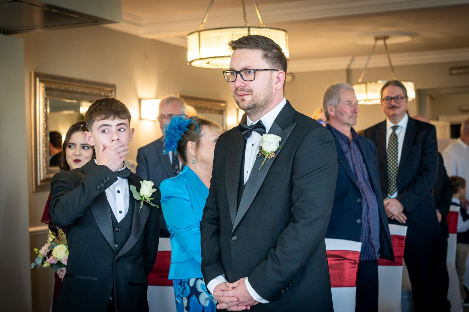 Groom and guests at wedding ceremony by Southampton wedding photographer John Watson