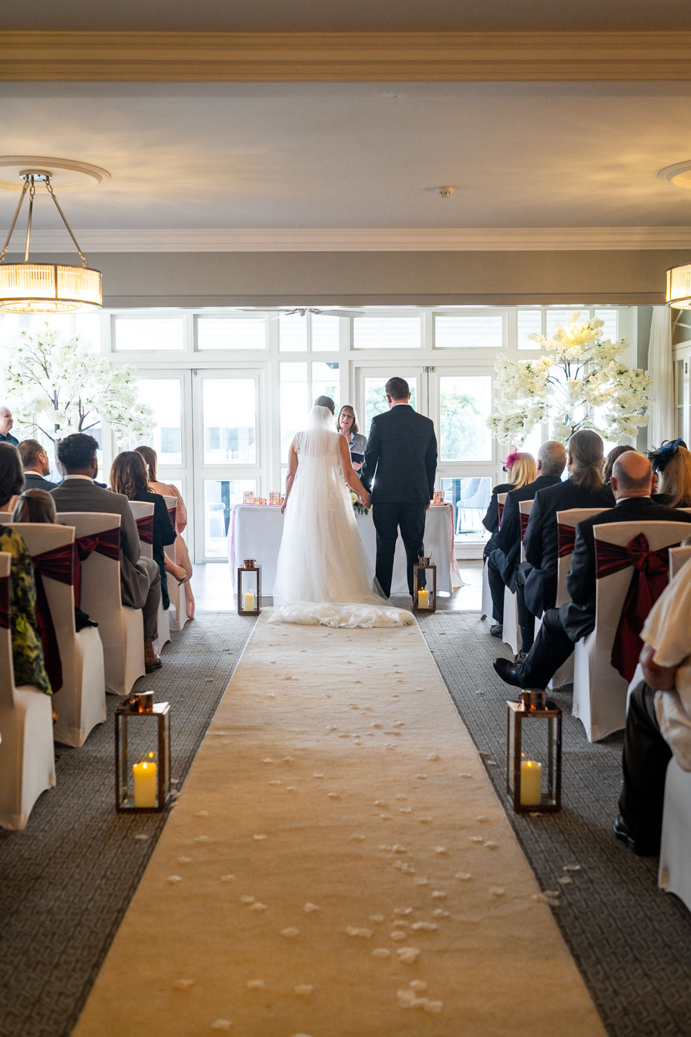 Indoor wedding ceremony with guests and couple by Southampton wedding photographer John Watson