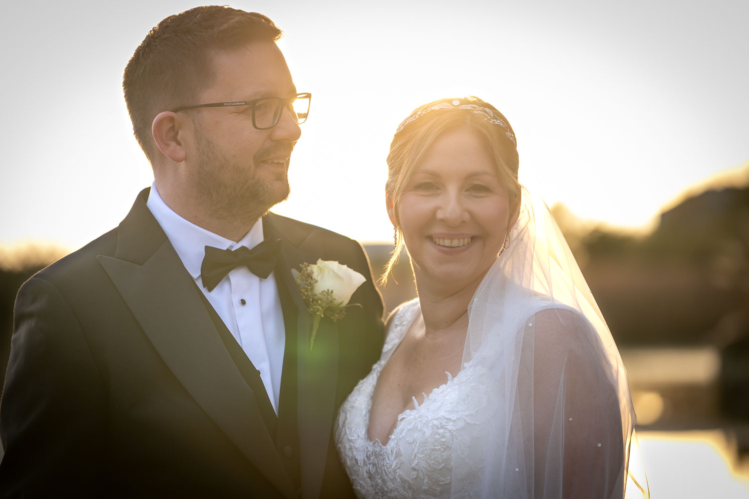 Smiling couple at sunset wedding by Southampton wedding photographer John Watson