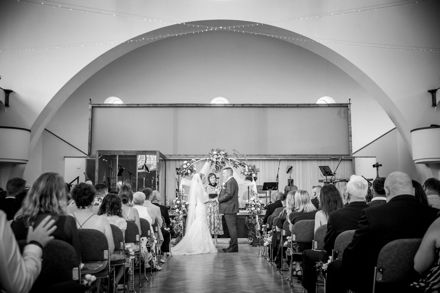 Bride and groom exchange vows in elegant venue by Southampton wedding photographer John Watson