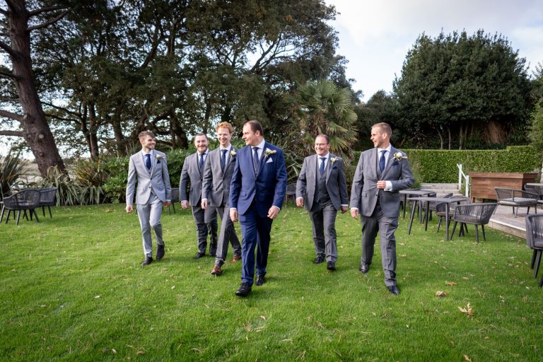 Groomsmen walking together outdoors at a wedding by Southampton wedding photographer John Watson