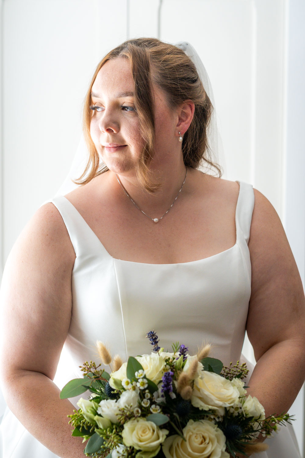 Bride with bouquet smiling on her wedding day by Southampton wedding photographer John Watson