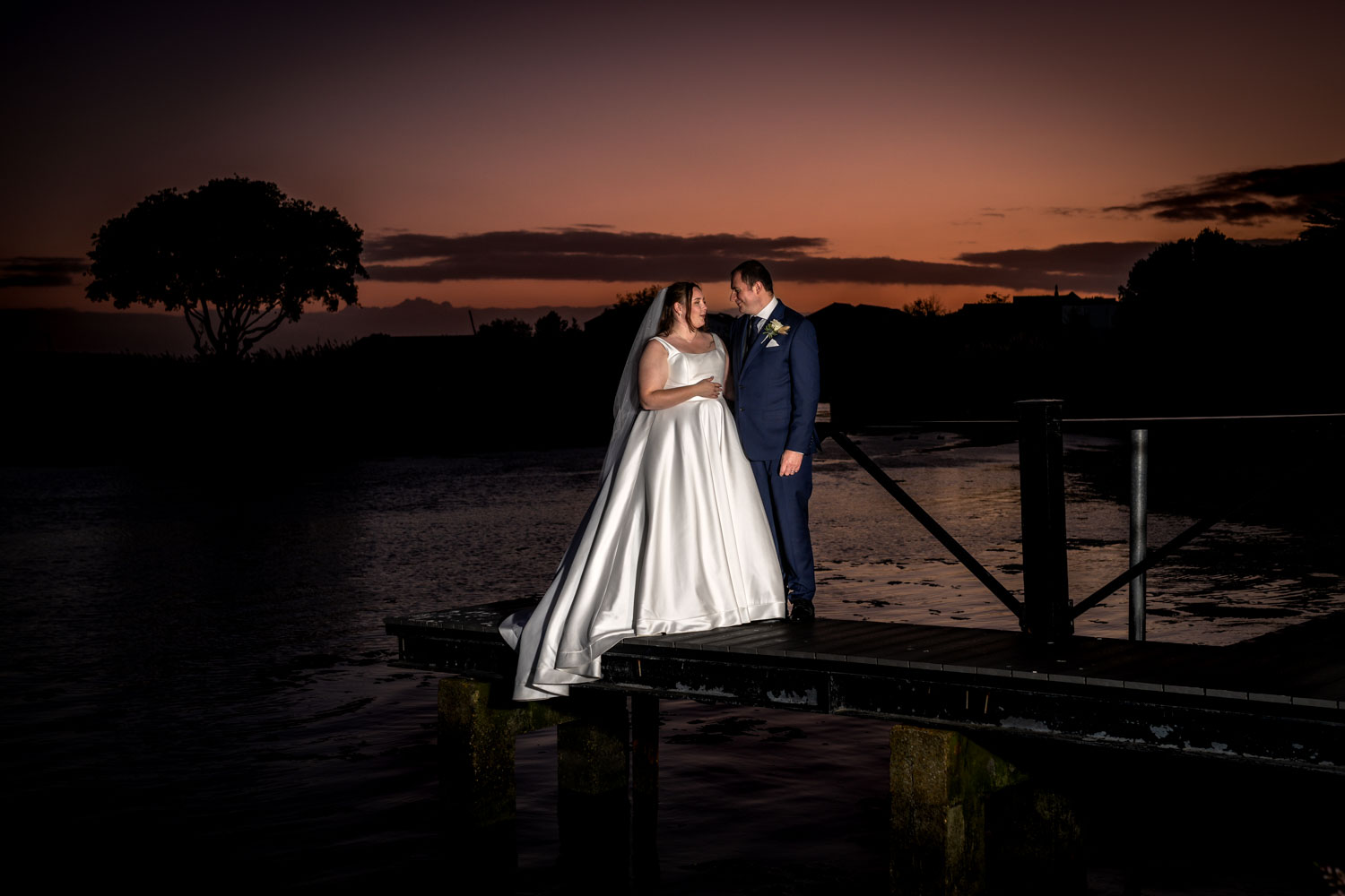 Newlyweds embracing at sunset by Southampton wedding photographer John Watson