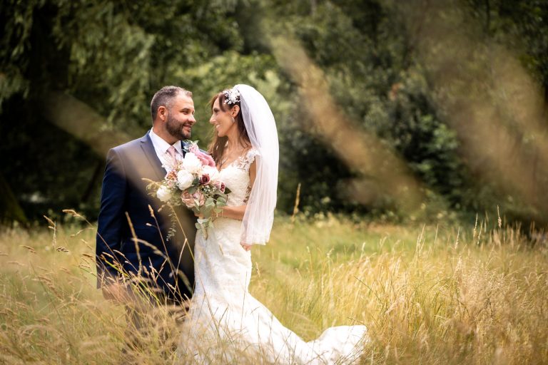 Bride and groom in sunlit meadow by Southampton wedding photographer John Watson