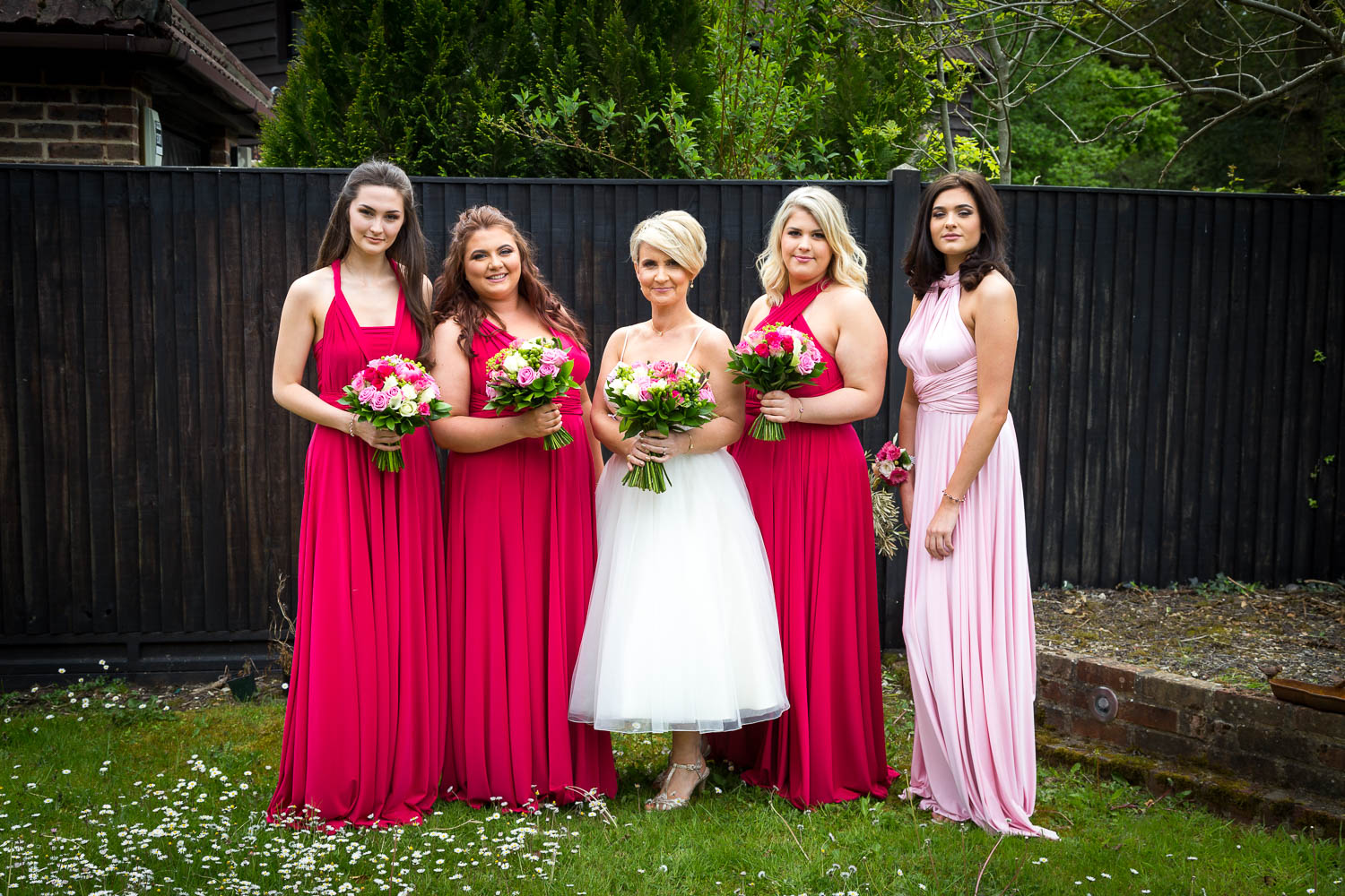 Bride and bridesmaids in garden by Southampton wedding photographer John Watson