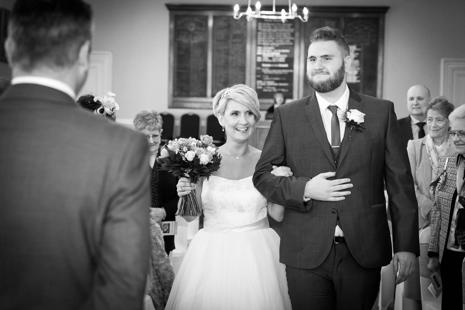 Bride and groom joyfully walk down aisle by Southampton wedding photographer John Watson