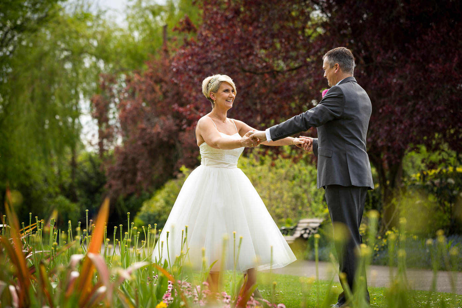 Bride and groom dancing in garden by Southampton wedding photographer John Watson