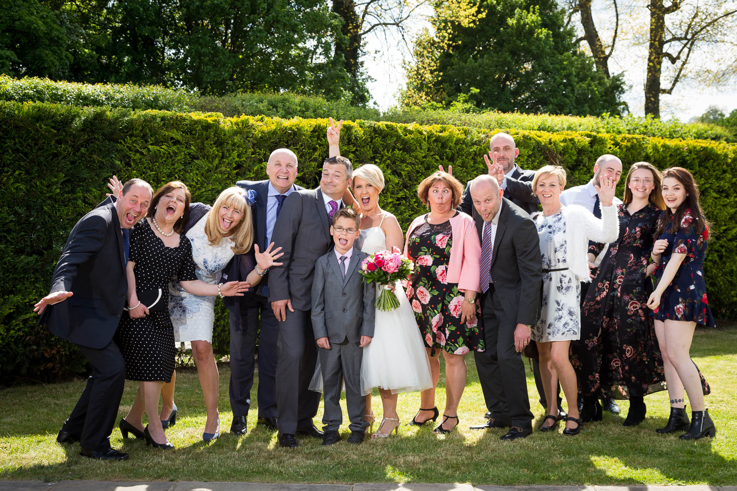 Joyful wedding gathering in garden setting by Southampton wedding photographer John Watson