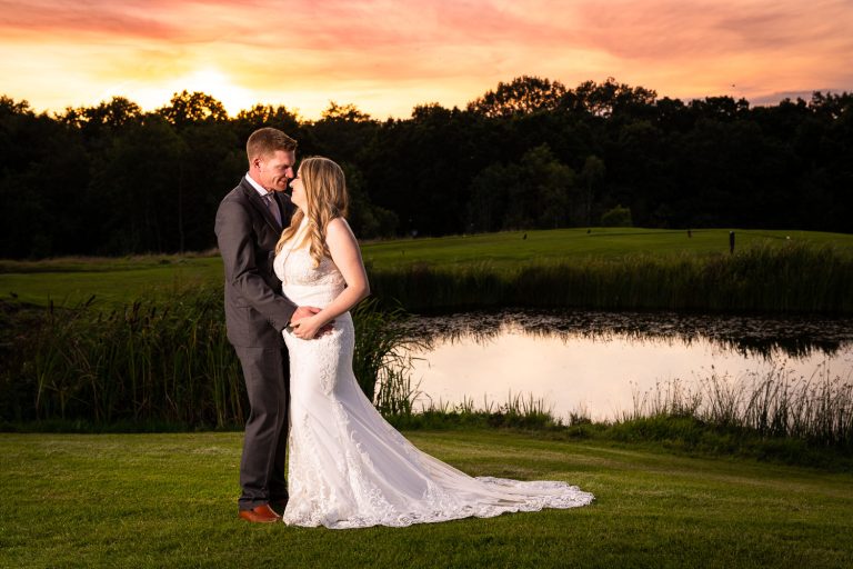 Bride and groom by lakeside at sunset by Southampton wedding photographer John Watson
