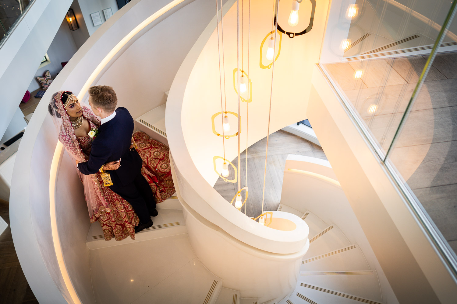 Elegant couple on spiral staircase by Southampton wedding photographer John Watson