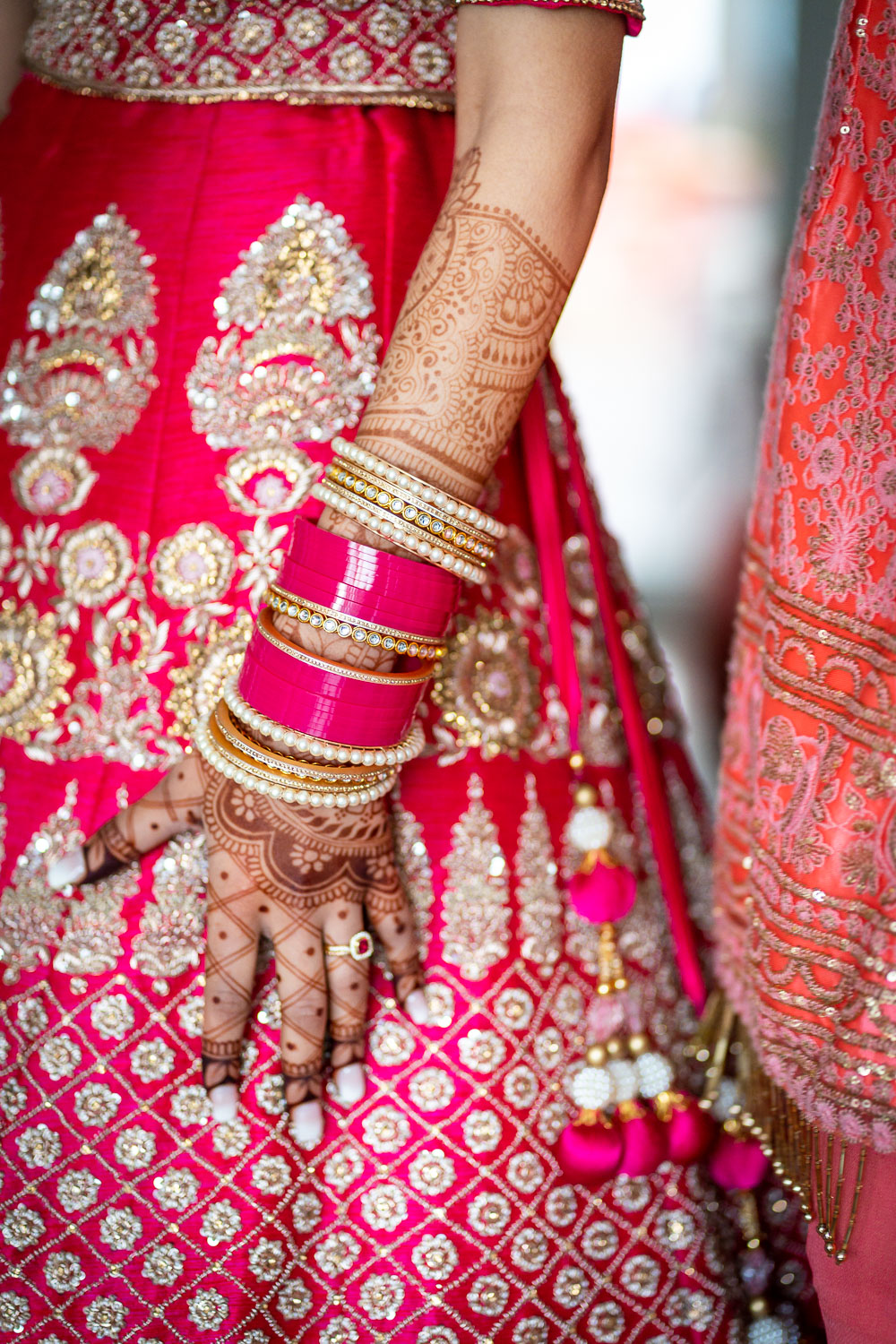 Bride in pink and gold attire with henna by Southampton wedding photographer John Watson