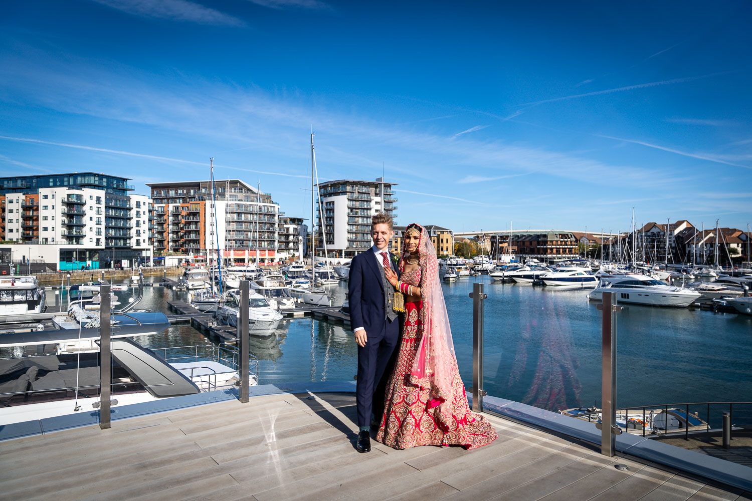 Couple at marina with elegant yachts by Southampton wedding photographer John Watson