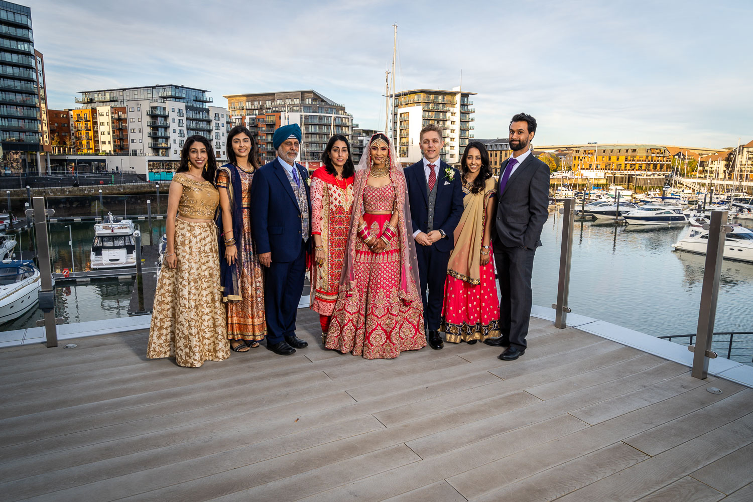 Elegant wedding group portrait with marina view by Southampton wedding photographer John Watson