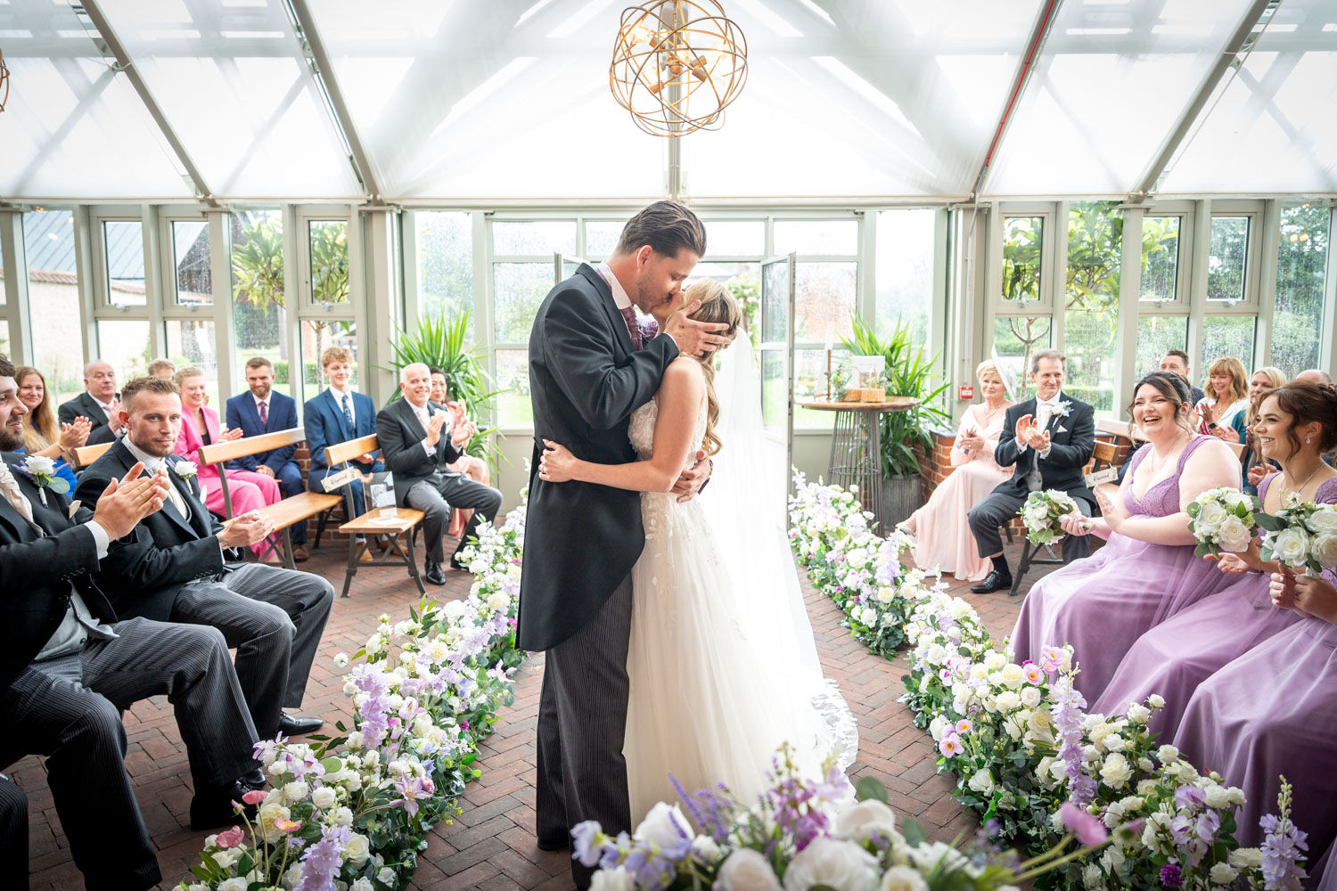 Bride and groom's first kiss in elegant wedding ceremony by Southampton wedding photographer John Watson