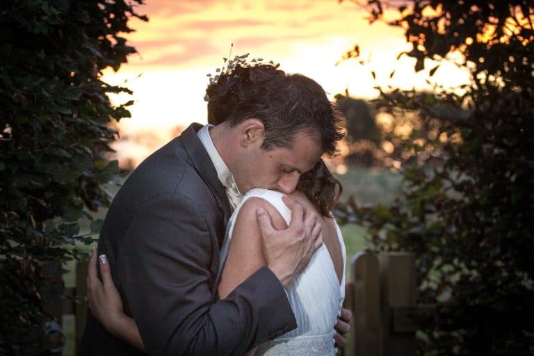 Couple embracing at sunset on wedding day by Southampton wedding photographer John Watson
