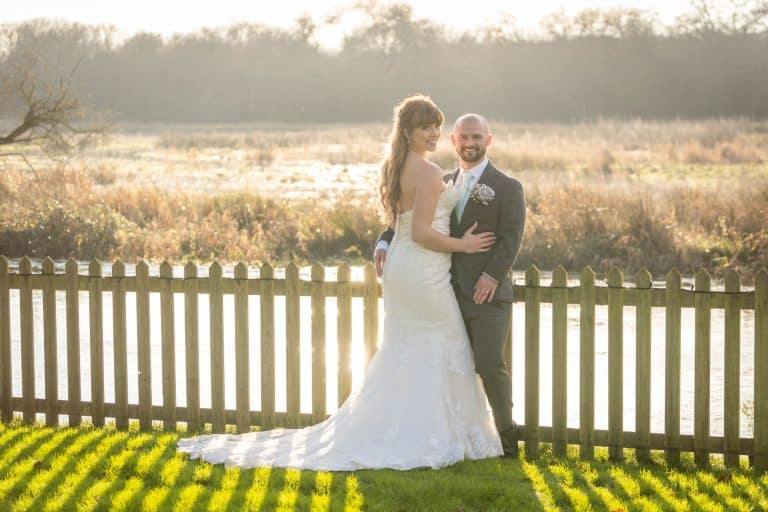 Bride and groom by serene riverside landscape by Southampton wedding photographer John Watson