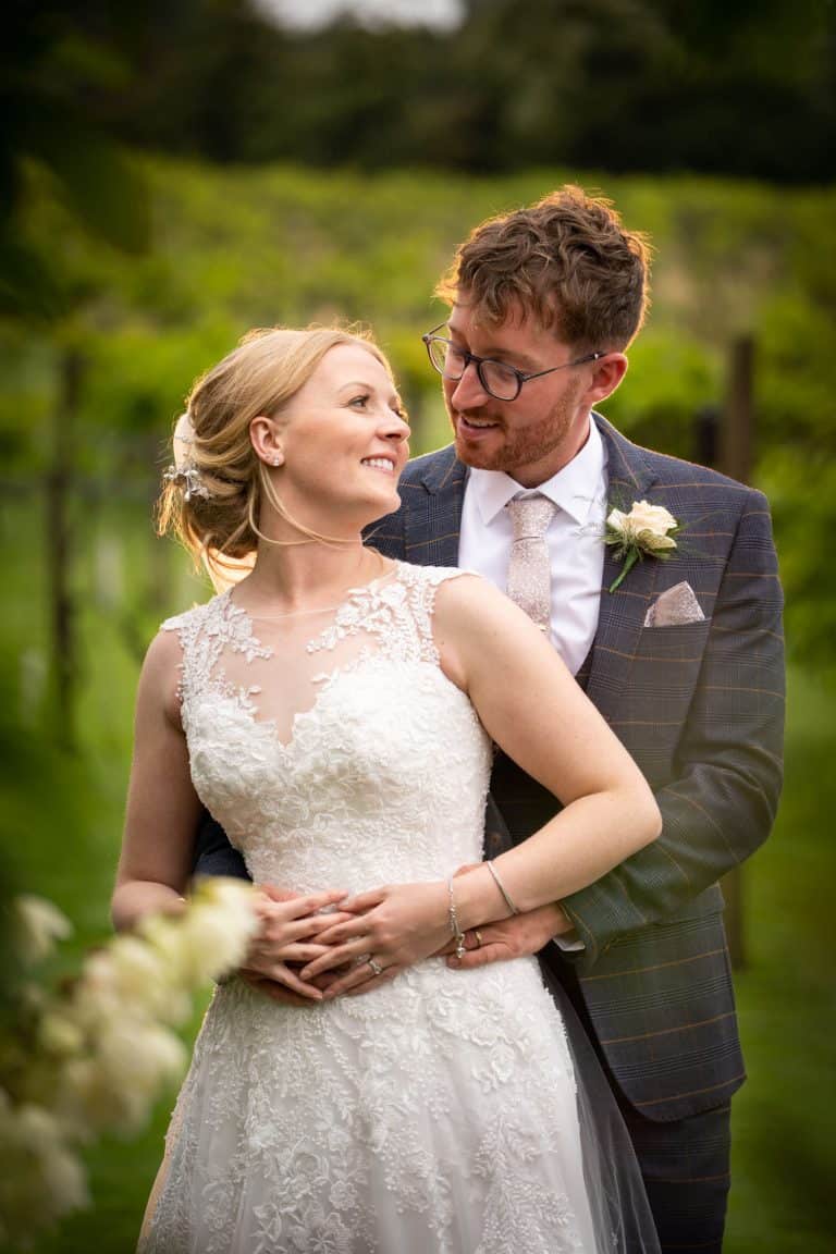 A bride and groom happily embrace outdoors by Southampton wedding photographer John Watson