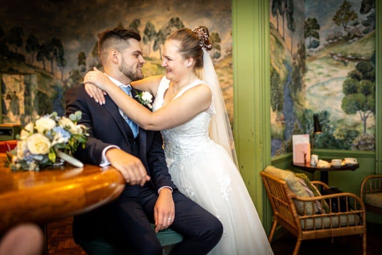 Bride and groom embracing in elegant venue by Southampton wedding photographer John Watson