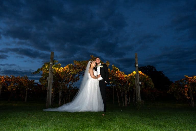 Bride and groom embracing in twilight vineyard setting by Southampton wedding photographer John Watson