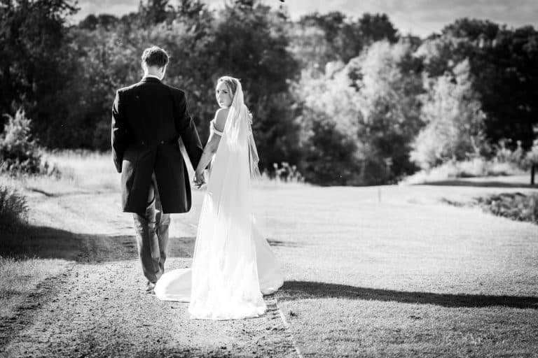 Bride and groom walking in nature by Southampton wedding photographer John Watson
