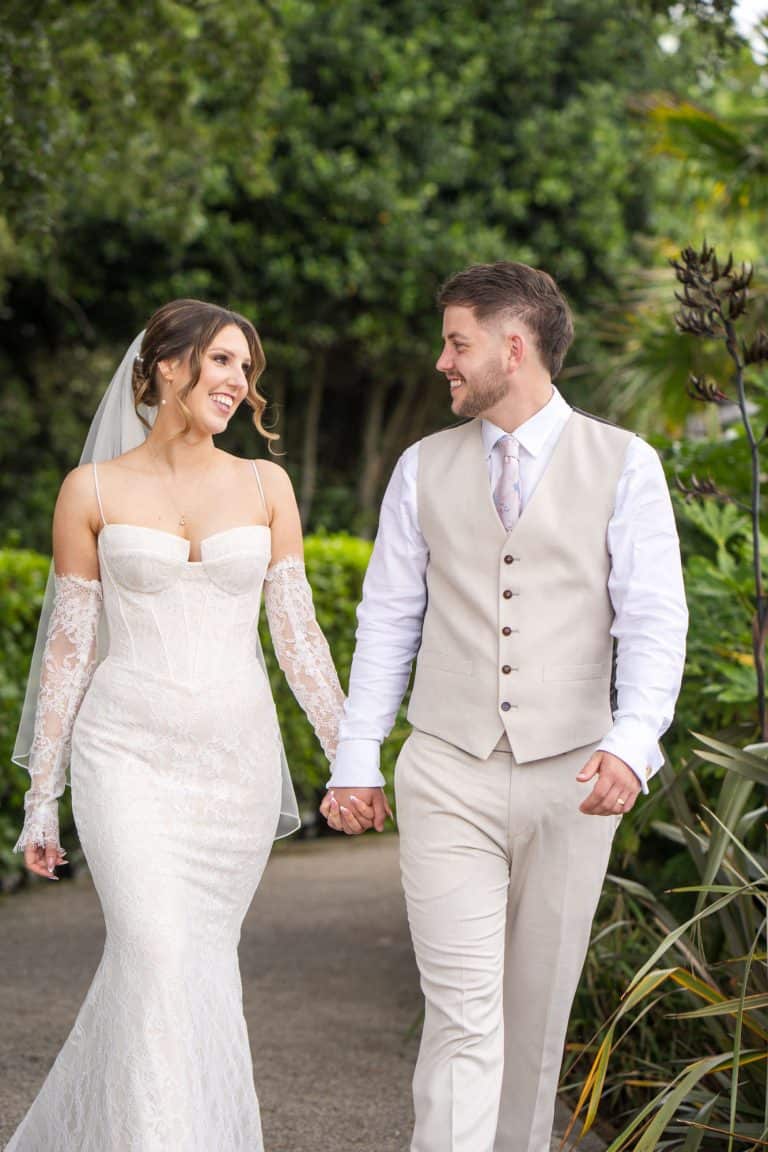 Elegant couple walking in garden on wedding day by Southampton wedding photographer John Watson