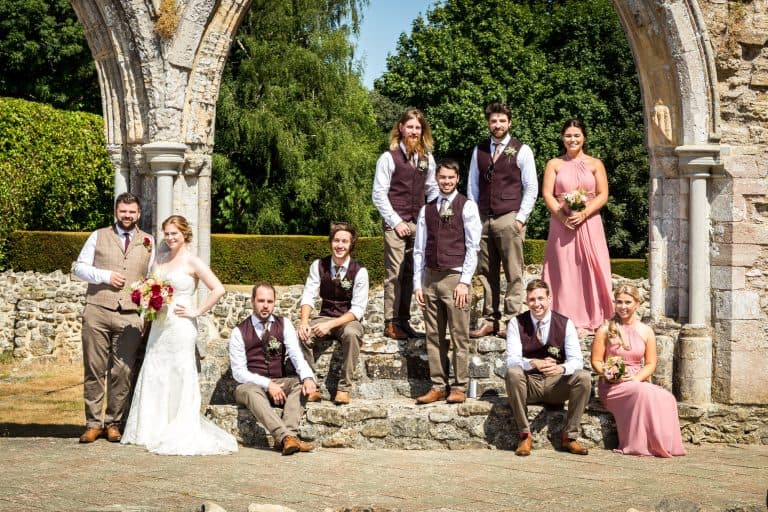 Wedding party posing outdoors at historic site by Southampton wedding photographer John Watson