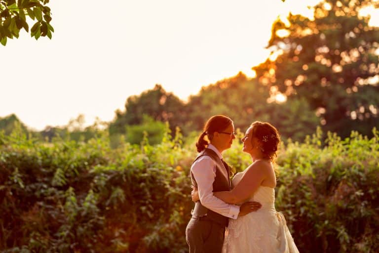 Sunset wedding embrace in lush garden by Southampton wedding photographer John Watson