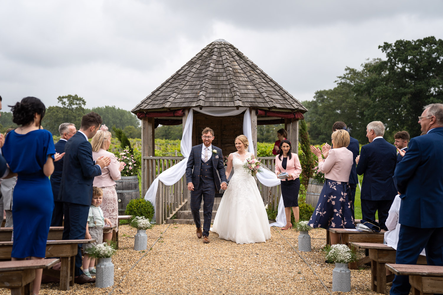Bride and groom walking down the aisle at outdoor wedding by Southampton wedding photographer John Watson
