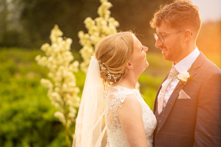 Bride and groom smiling in sunset garden by Southampton wedding photographer John Watson