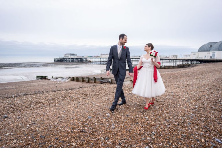 Newlywed couple walking on a beach by Southampton wedding photographer John Watson
