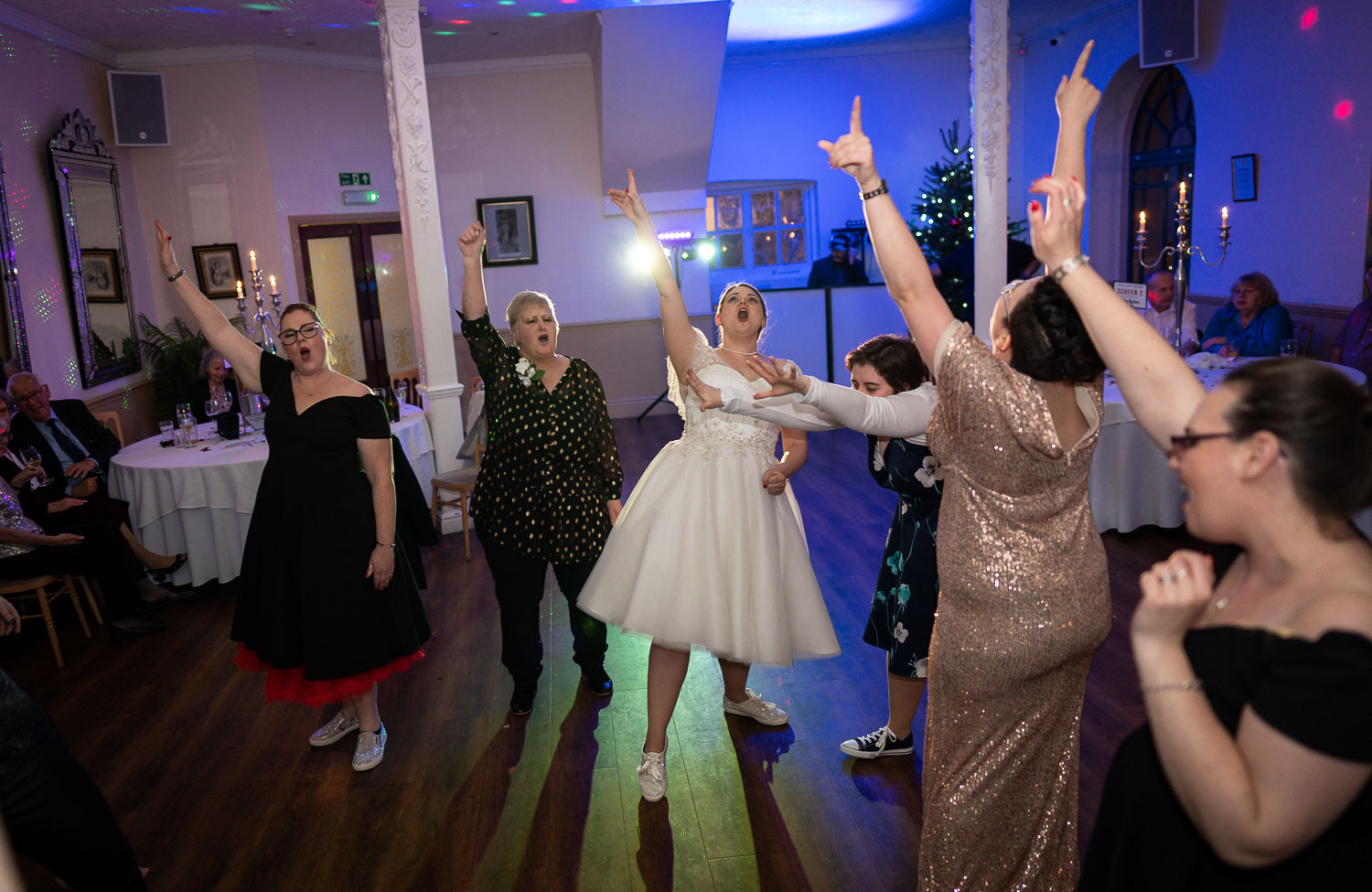 Bride and guests dancing joyfully at wedding reception by Southampton wedding photographer John Watson