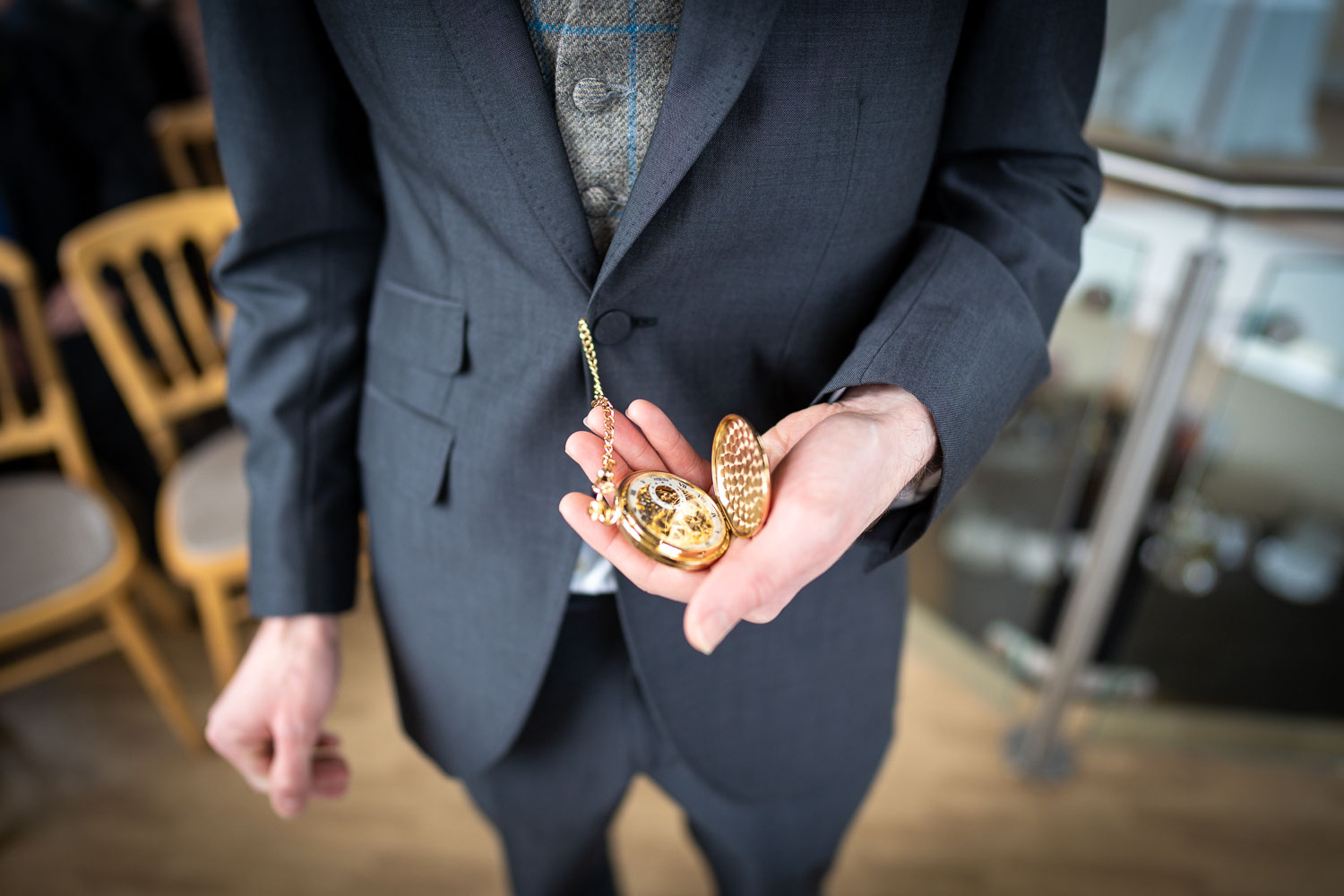 Close-up of groom holding gold pocket watch by Southampton wedding photographer John Watson