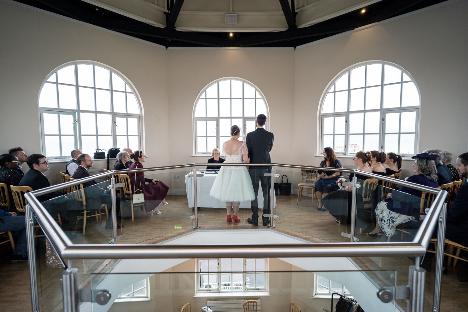 Couple exchanging vows in bright venue by Southampton wedding photographer John Watson