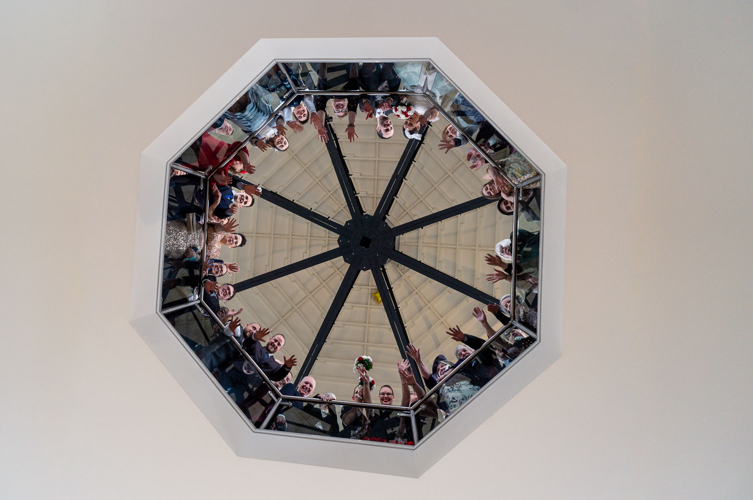 Wedding guests reflecting in ceiling mirror by Southampton wedding photographer John Watson