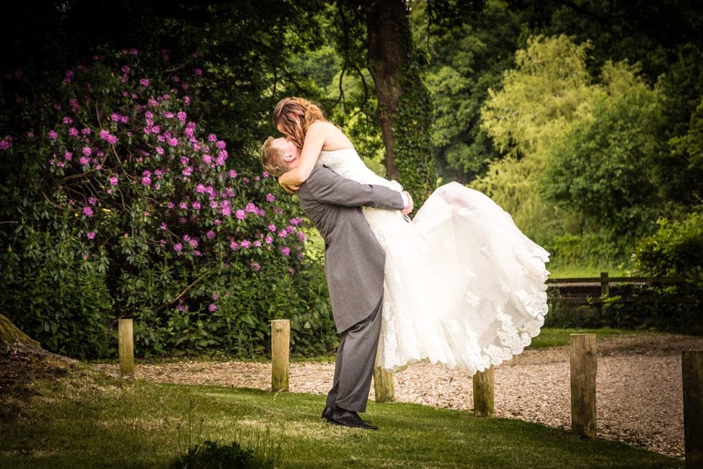Bride and groom embrace in garden setting by Southampton wedding photographer John Watson