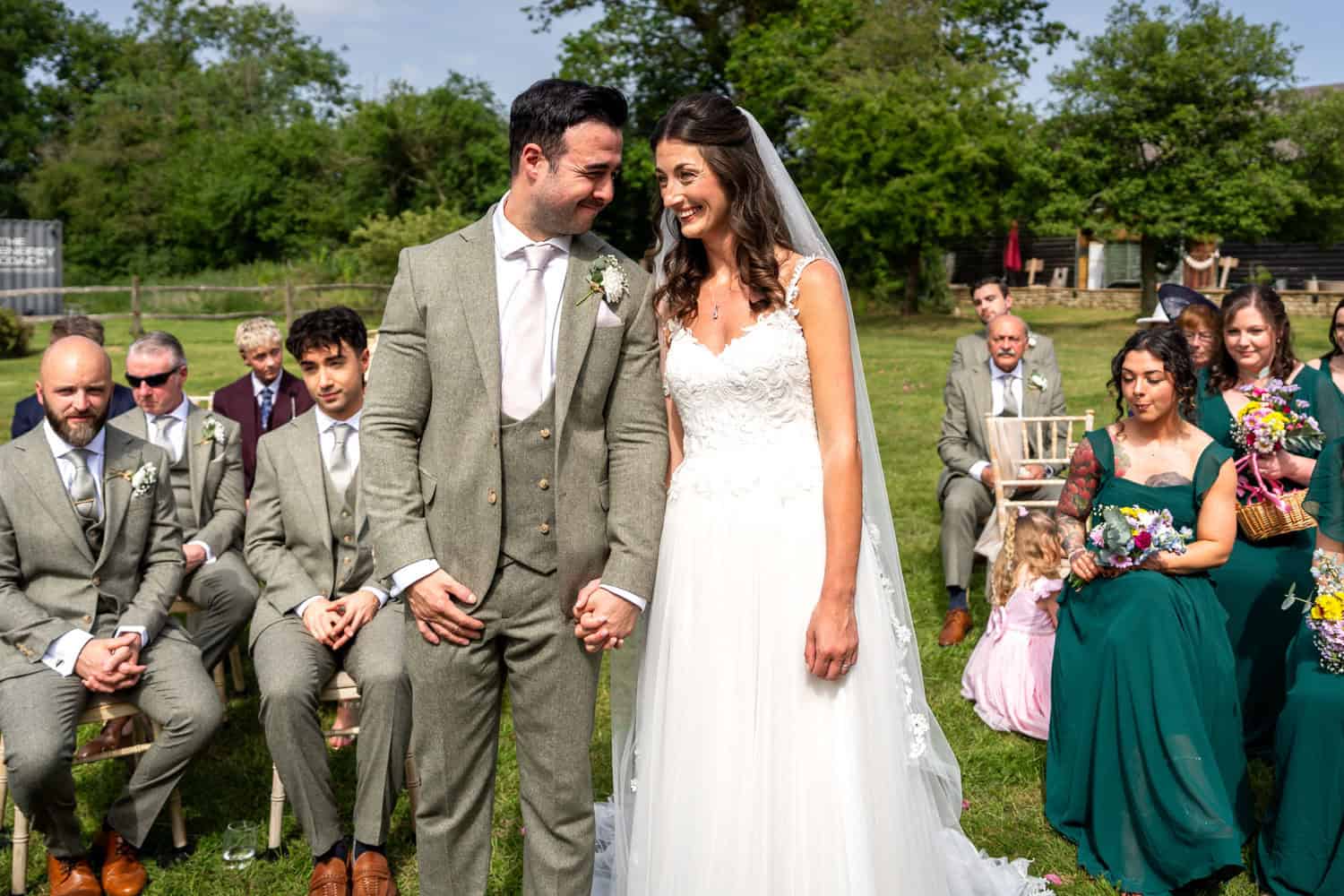 Bride and groom smiling with guests outdoors by Southampton wedding photographer John Watson