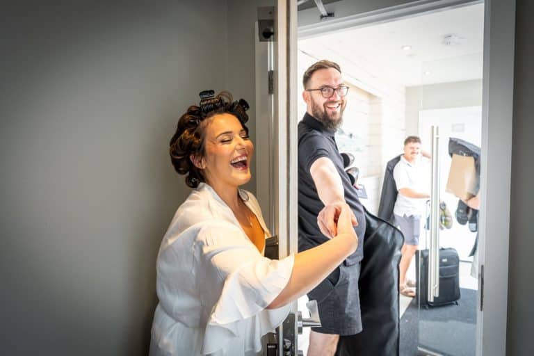 Bride laughing with bridal party before wedding by Southampton wedding photographer John Watson