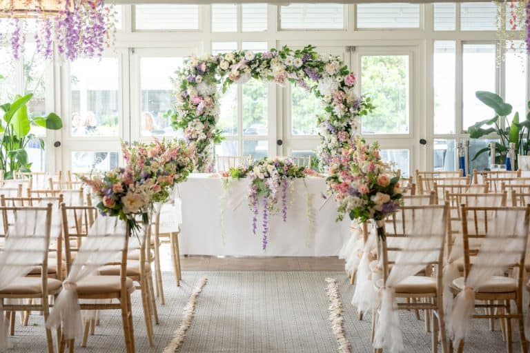 Elegant wedding ceremony setup with floral arch by Southampton wedding photographer John Watson