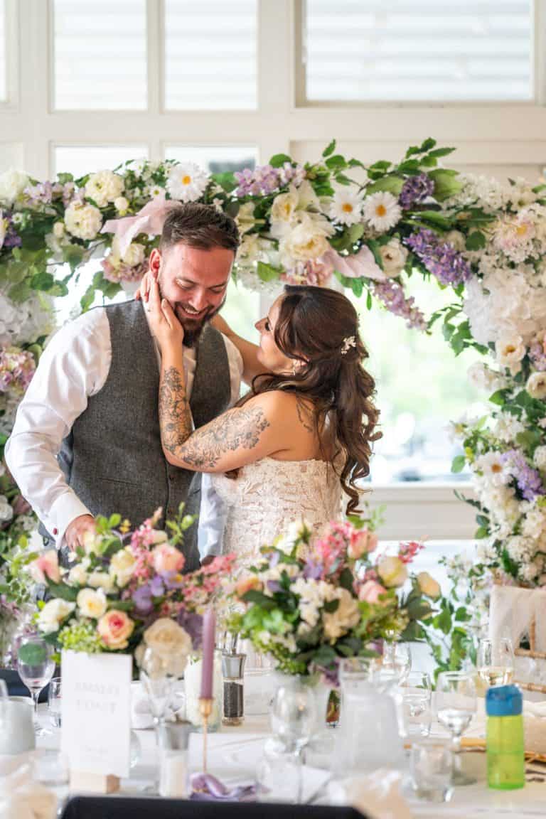 Bride and groom sharing a joyful moment at wedding reception by Southampton wedding photographer John Watson