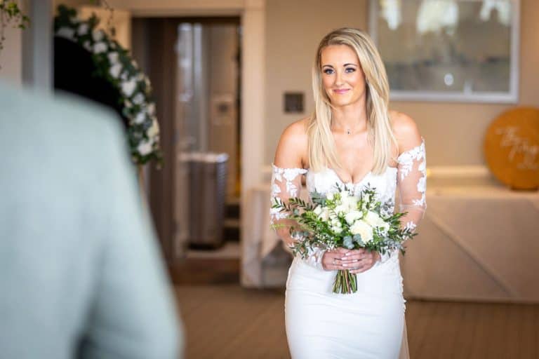Bride holding bouquet indoors by Southampton wedding photographer John Watson