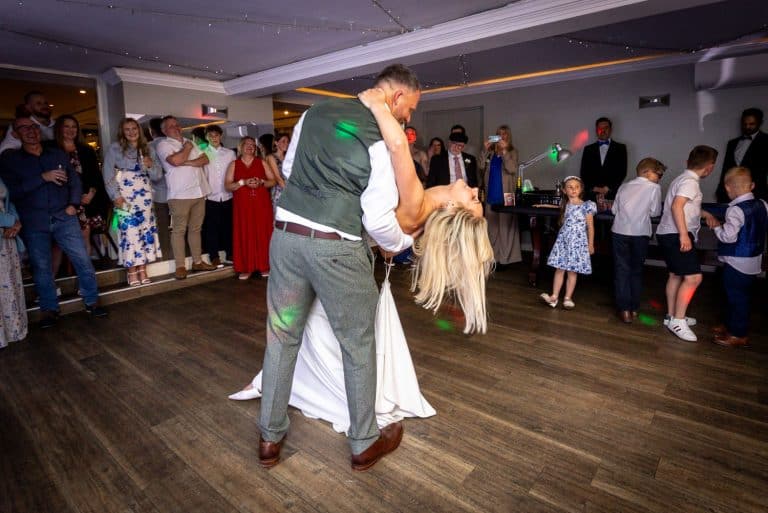 Bride and groom dancing joyfully on wedding day by Southampton wedding photographer John Watson