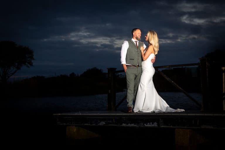 Bride and groom under dramatic evening sky by Southampton wedding photographer John Watson