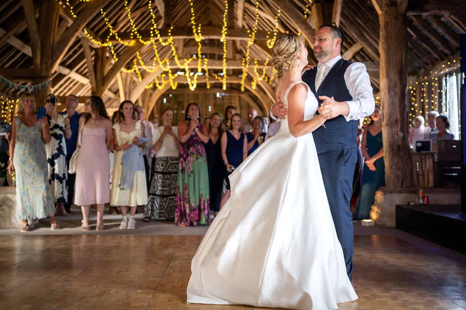 Bride and groom dancing in rustic barn wedding by Southampton photographer John Watson