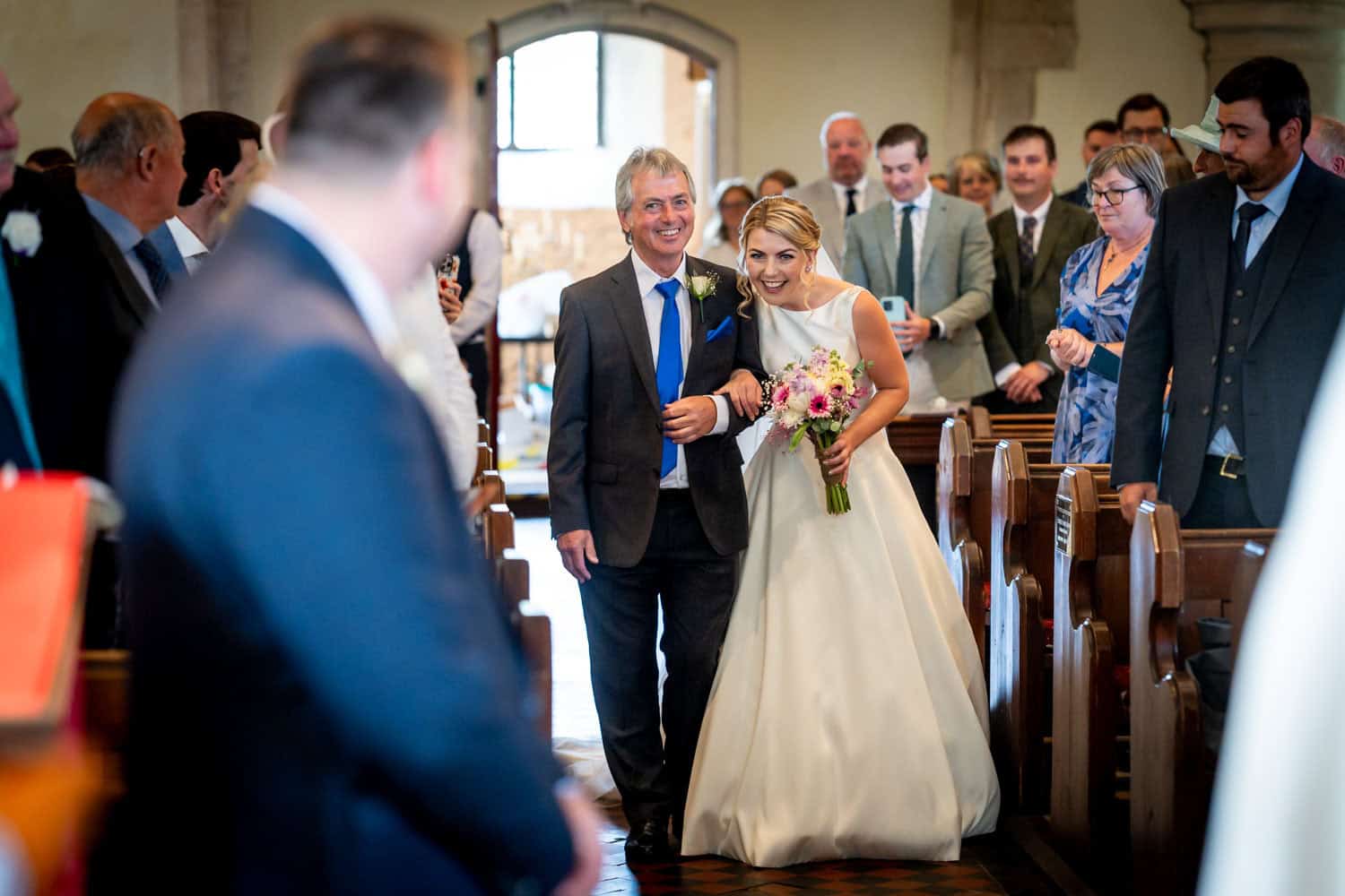 Bride walking down the aisle with her father in church by Southampton wedding photographer John Watson